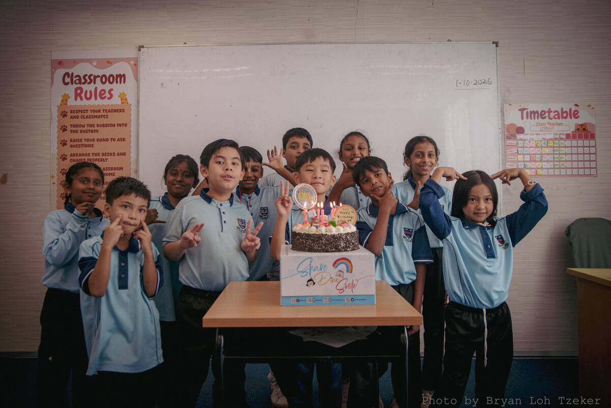 Pupils singing as their classmate blows out the birthday candles
