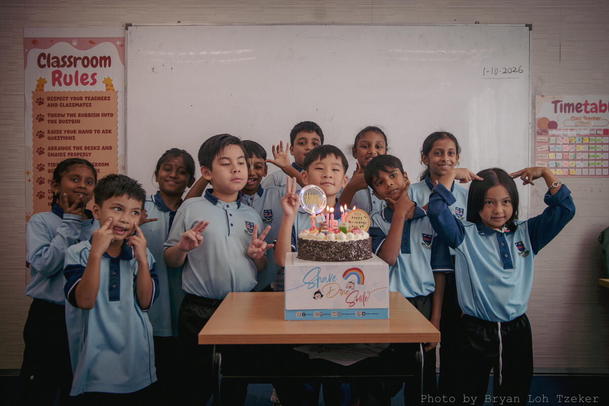 Pupils singing as their classmate blows out the birthday candles