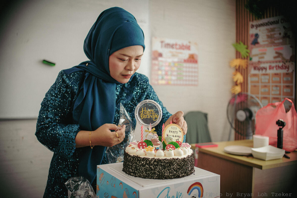 Pupils singing as their classmate blows out the birthday candles