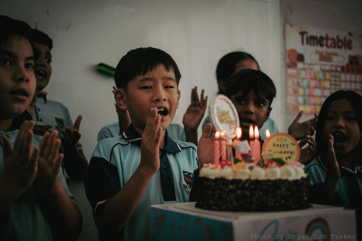 Pupils singing as their classmate blows out the birthday candles