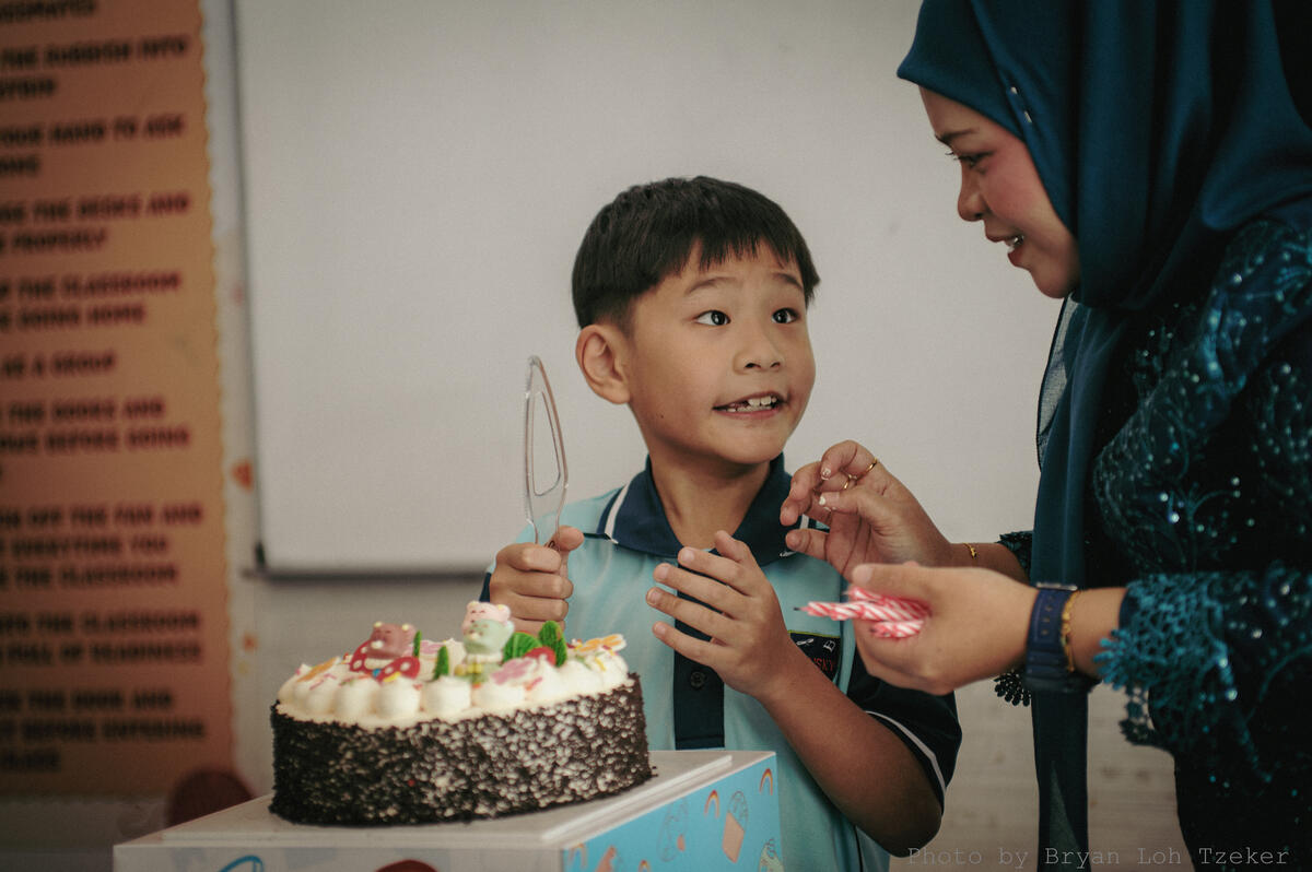 Pupils singing as their classmate blows out the birthday candles