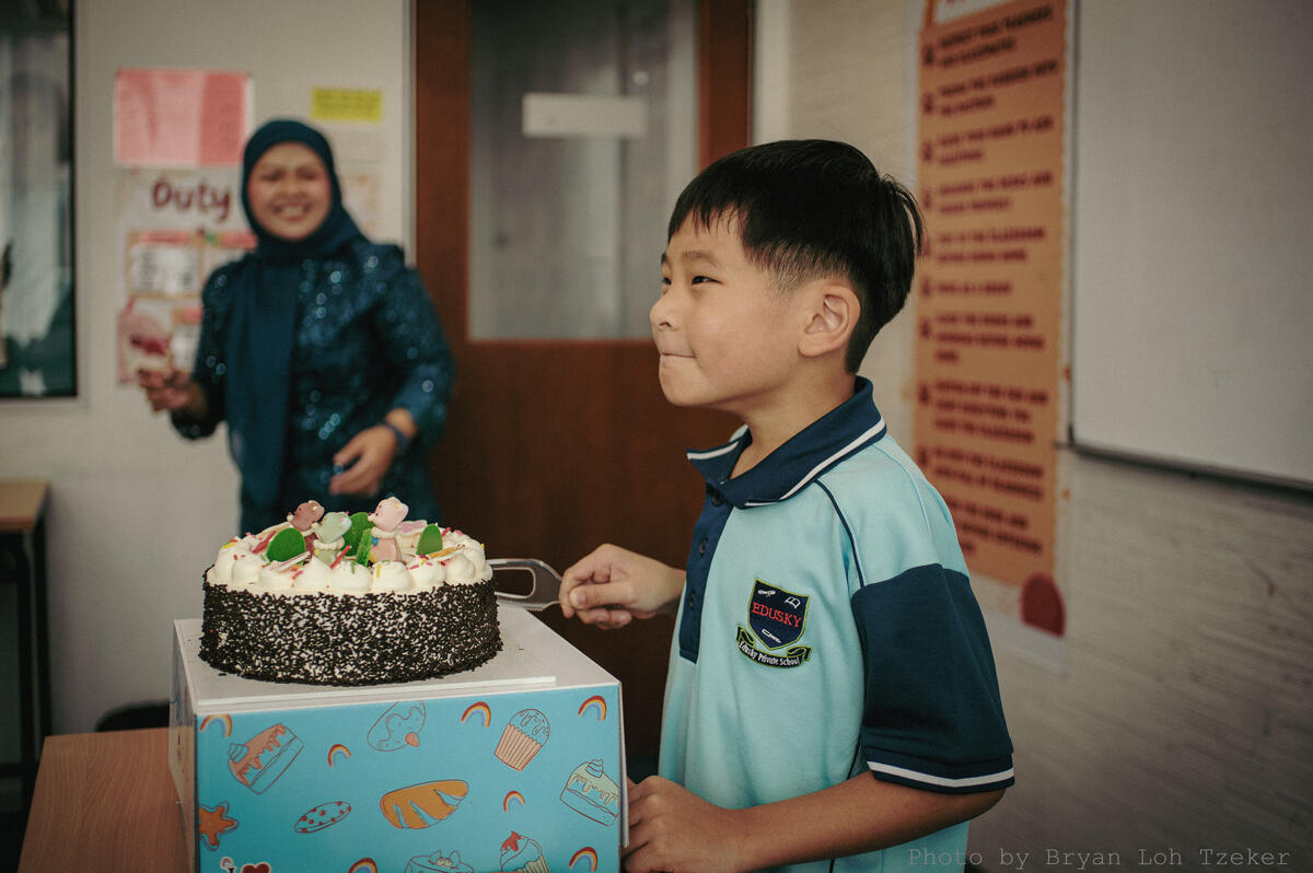 Pupils singing as their classmate blows out the birthday candles