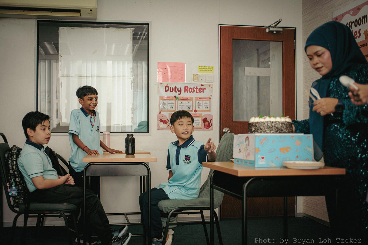 Pupils singing as their classmate blows out the birthday candles