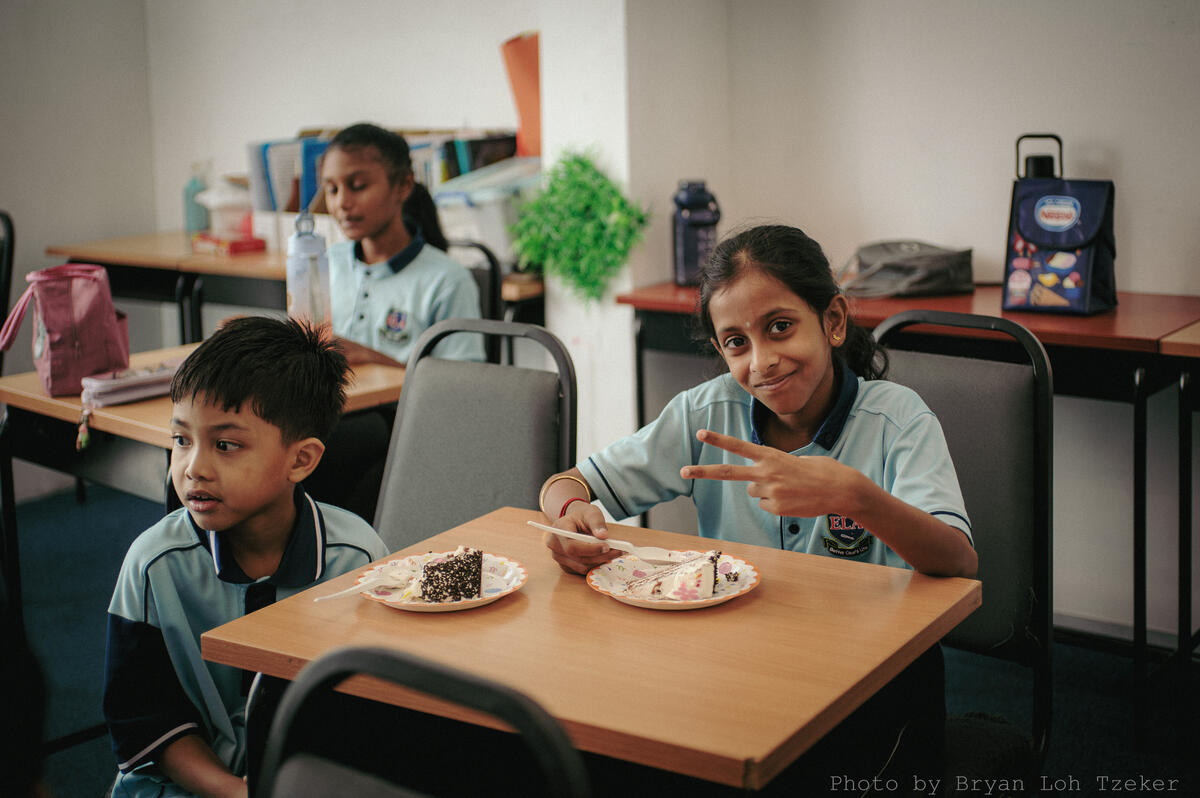 Pupils singing as their classmate blows out the birthday candles