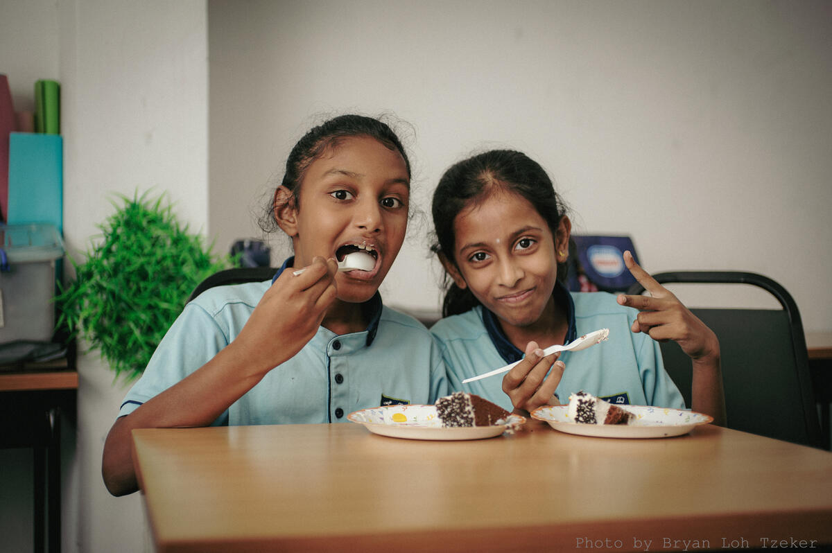 Pupils singing as their classmate blows out the birthday candles