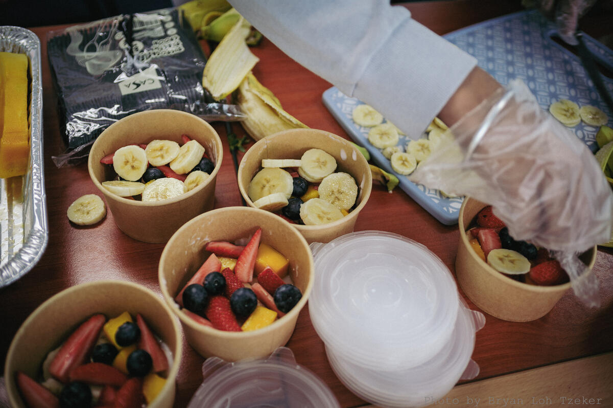Pupils preparing fruit cups for customers