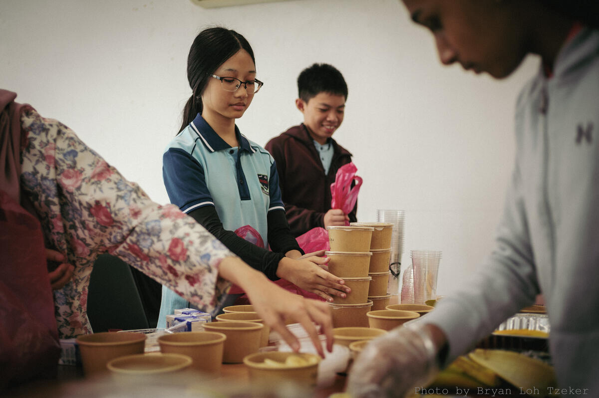 Pupils serving food to younger classmates