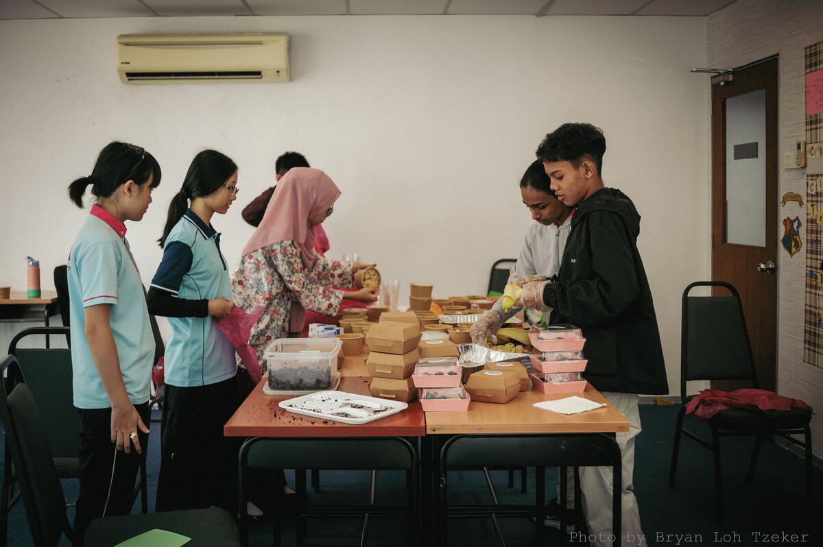 Pupils wearing gloves while preparing desserts