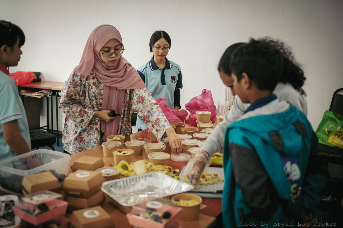 Pupils preparing boxed desserts for customers