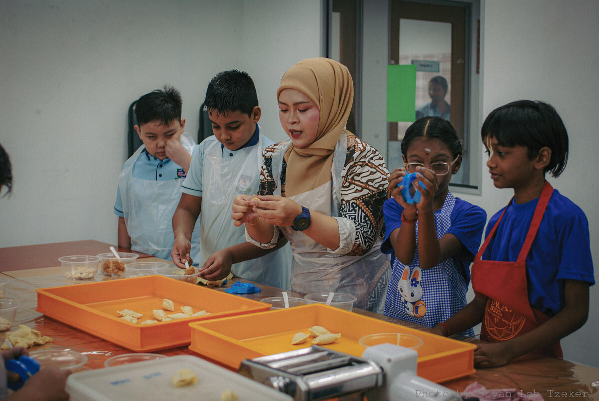 Pupils cooking Malaysian dishes together for Merdeka
