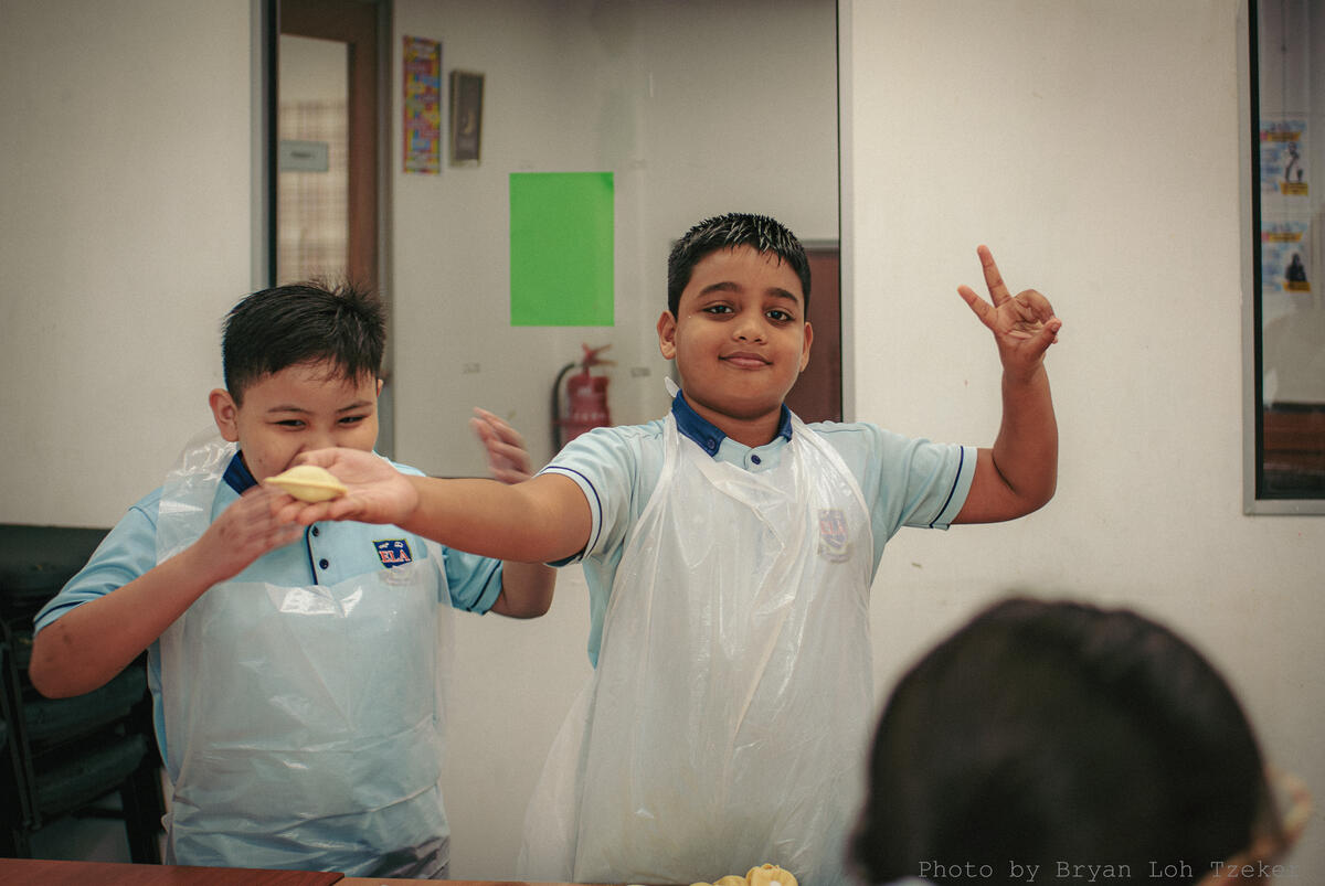 Pupils preparing food in class for the Merdeka celebration