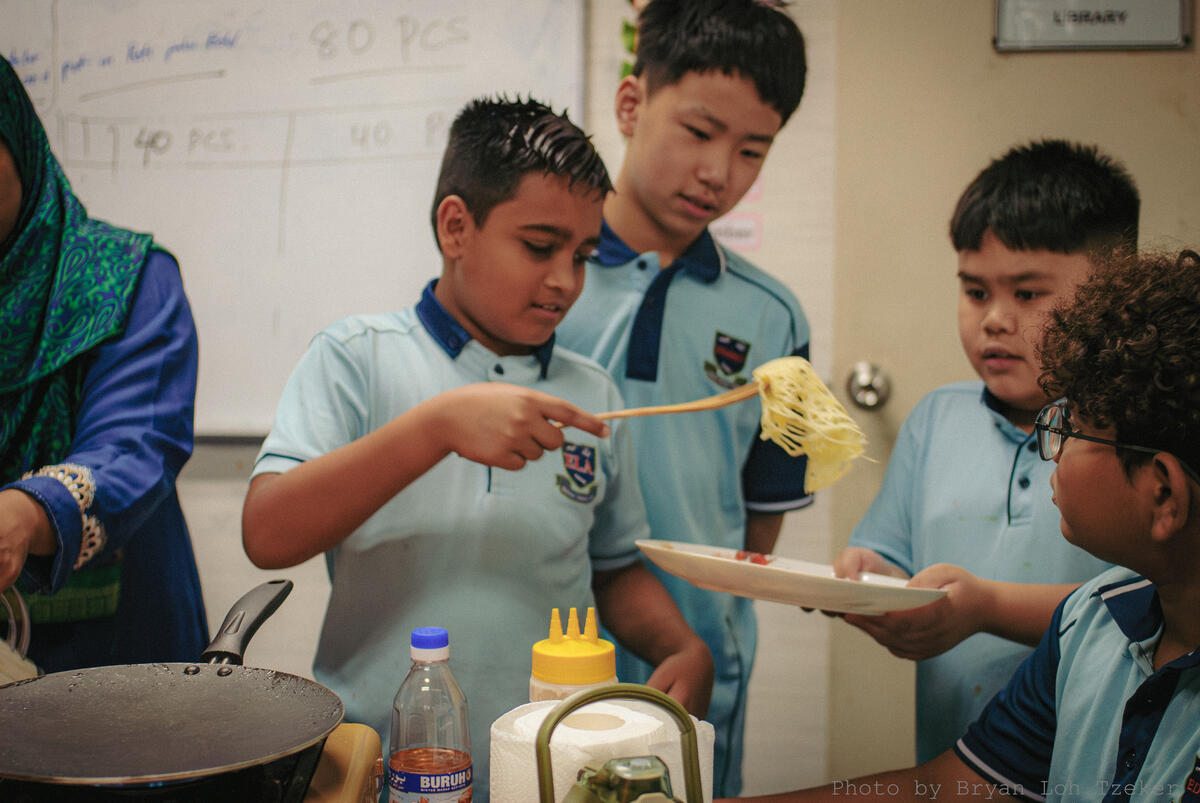 Pupils working together in the kitchen for Merdeka