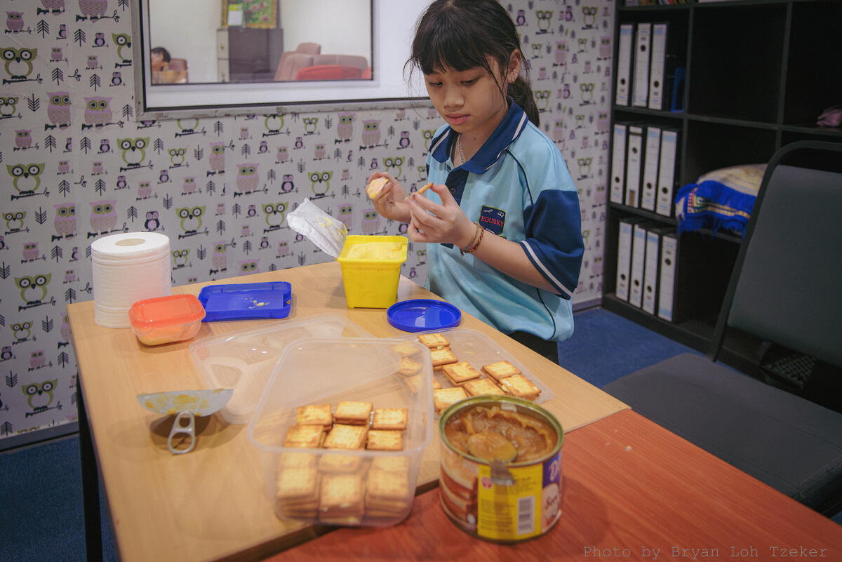 Pupils cutting and preparing fruit for Merdeka