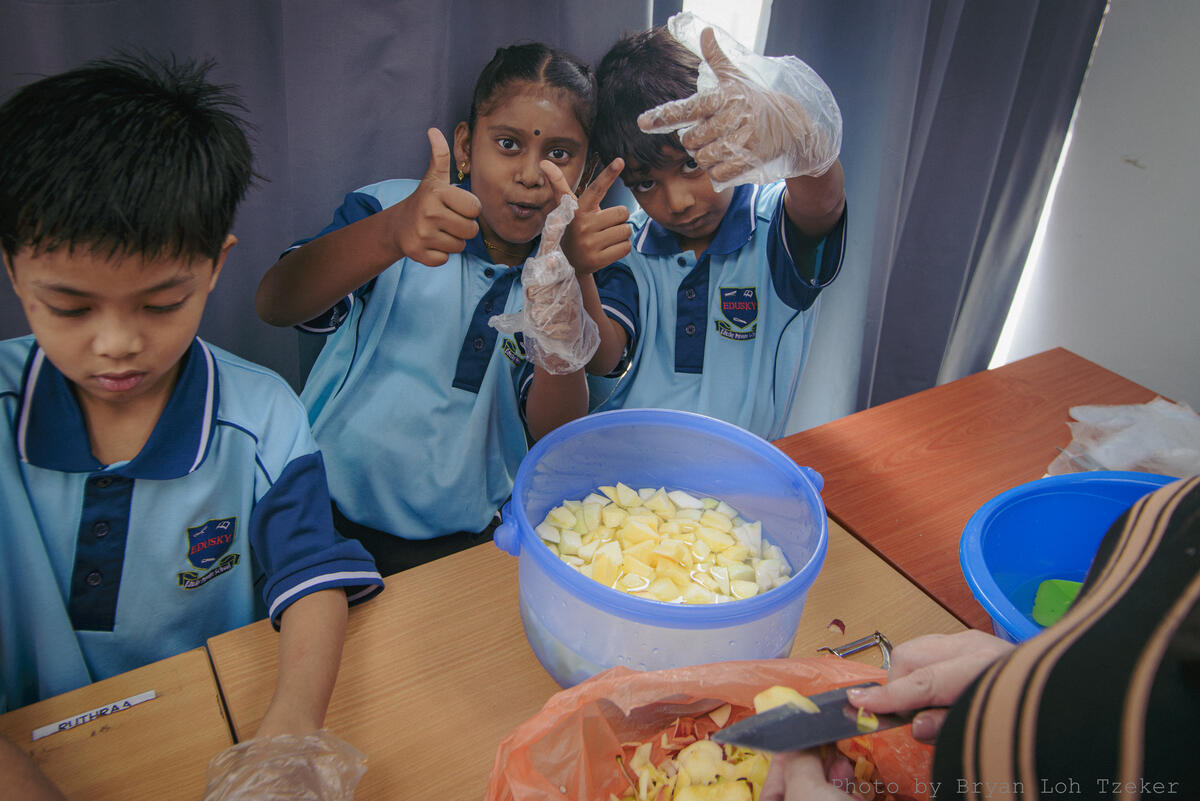 Pupils decorating a Merdeka celebration dish