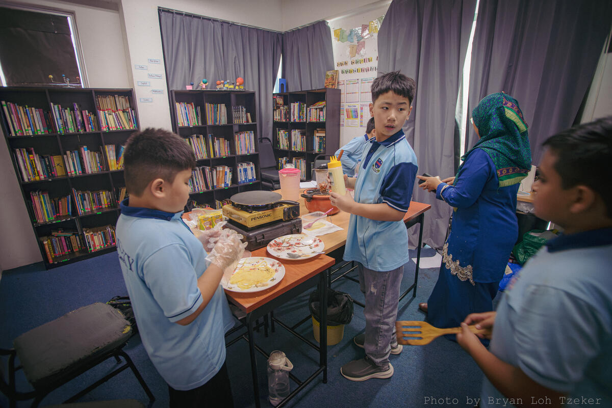 Pupils mixing ingredients for a Merdeka recipe