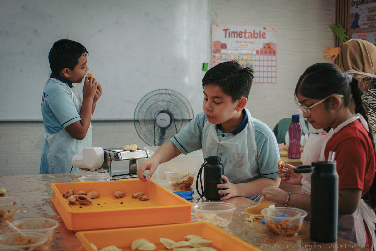 Pupils rolling and shaping pastry for Merdeka treats
