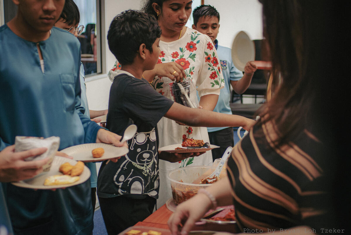 Pupils enjoying their Merdeka feast at long tables
