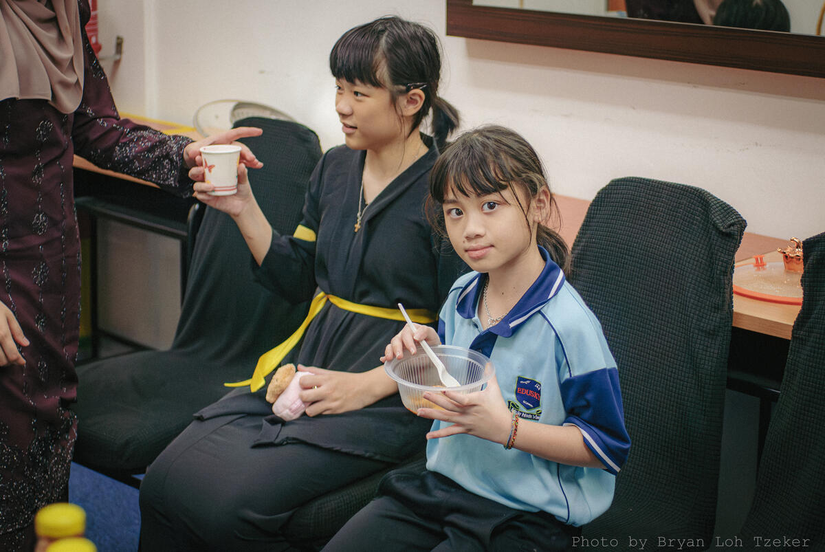 Pupils and teachers eating Malaysian favourites together