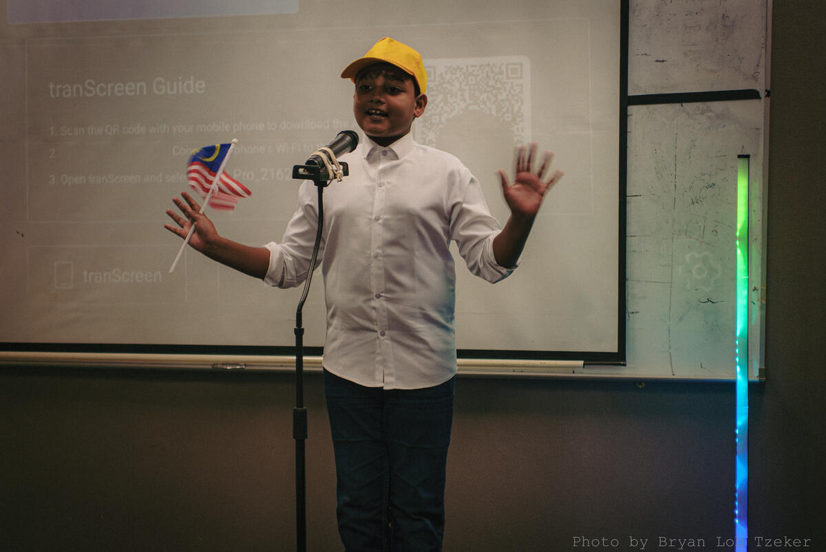 Pupils waving the Jalur Gemilang on stage