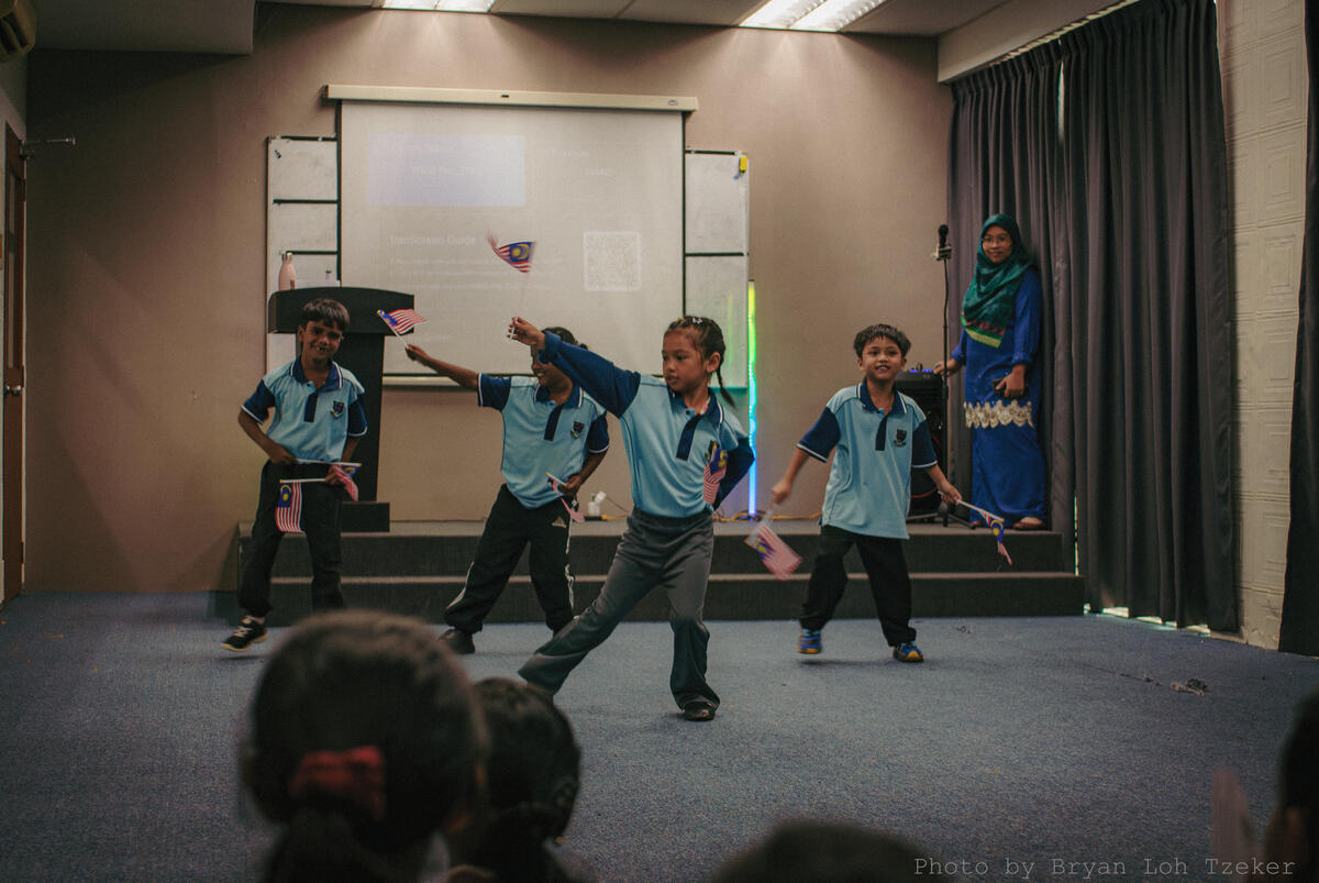 Pupils performing a flag routine for Merdeka