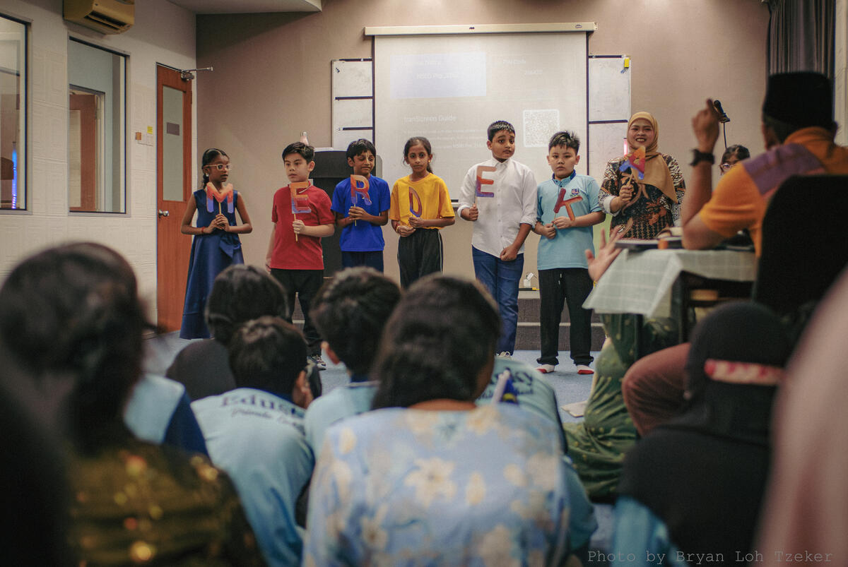 A pupil speaking into a microphone at Merdeka
