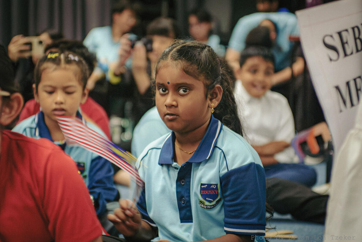 Pupils holding small Malaysian flags during Merdeka
