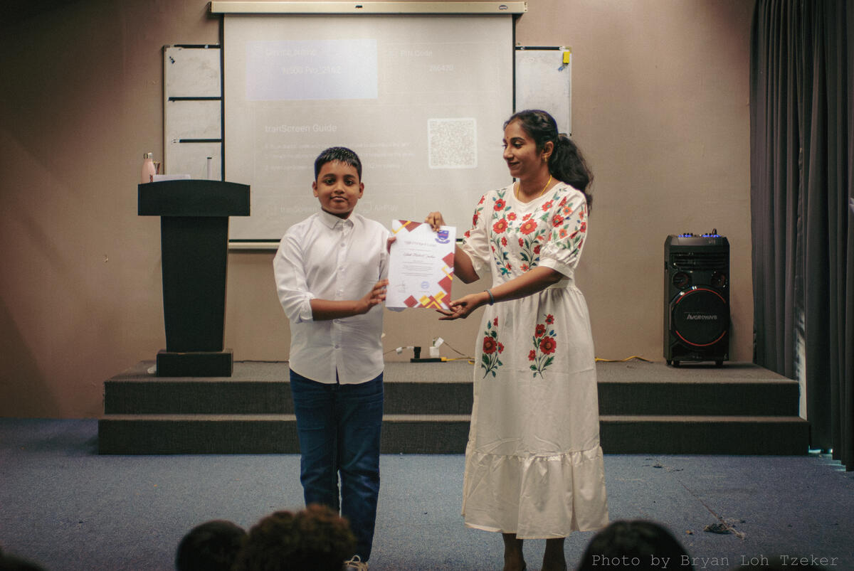 A pupil receiving a certificate at the Merdeka assembly