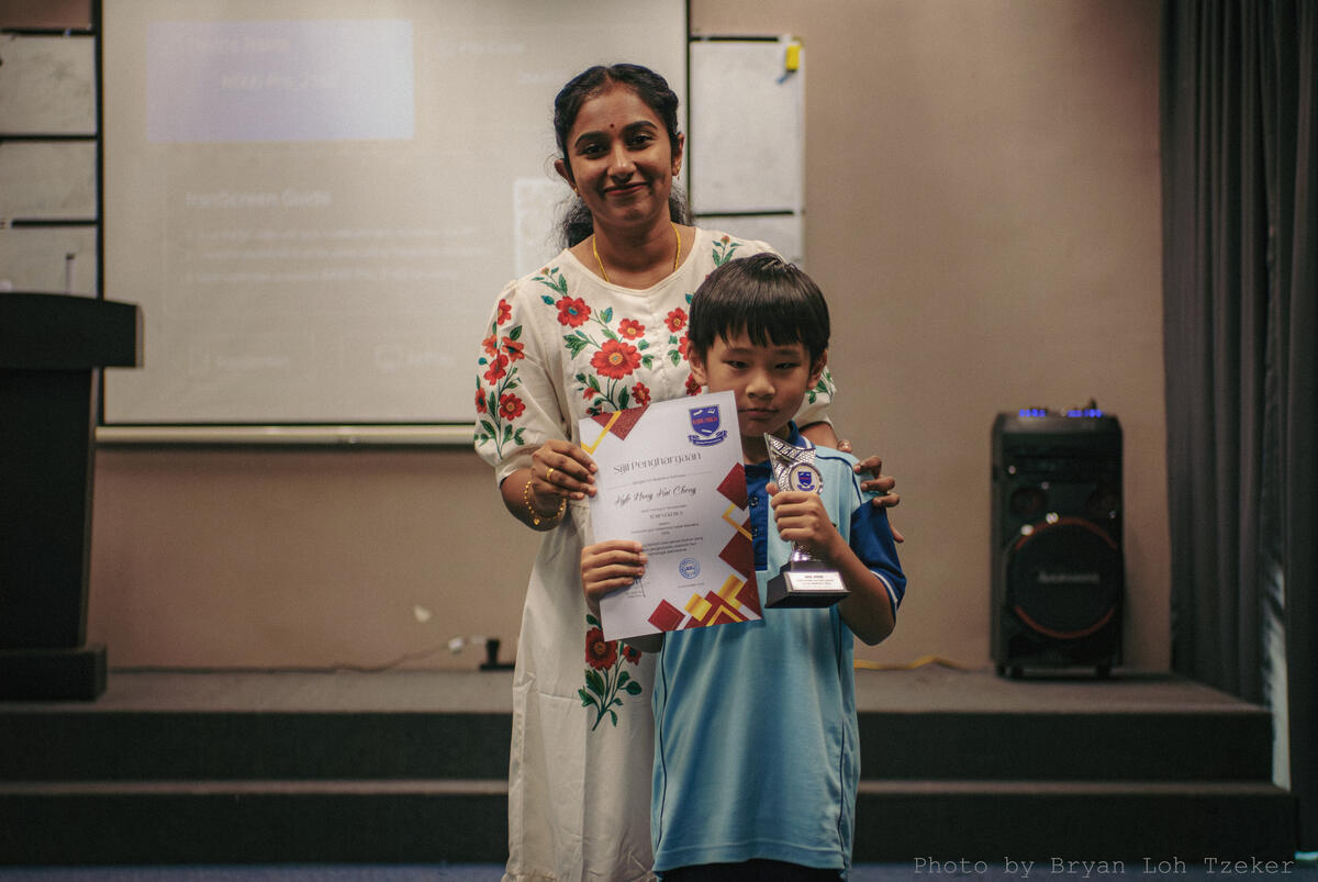 A certificate being presented during Merdeka celebrations